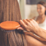 Woman brushing healthy beautiful hair and scalp